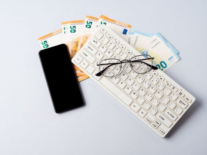 Euro money banknotes, keyboard, smartphone and glasses, online banking, business, student loan