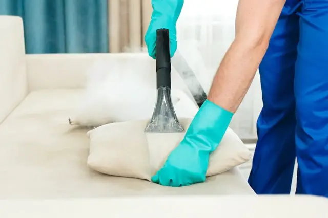 une entreprise de nettoyage fournit un service de nettoyage chimique et à la vapeur pour le canapé blanc